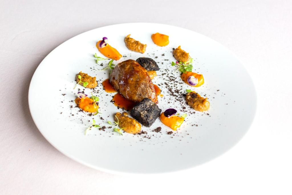 a white plate with food on a white table at Hotel Gastronómico Torre de Galizano in Galizano