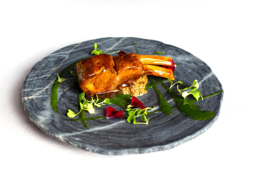 a plate of food with meat and vegetables on it at Hotel Gastronómico Torre de Galizano in Galizano
