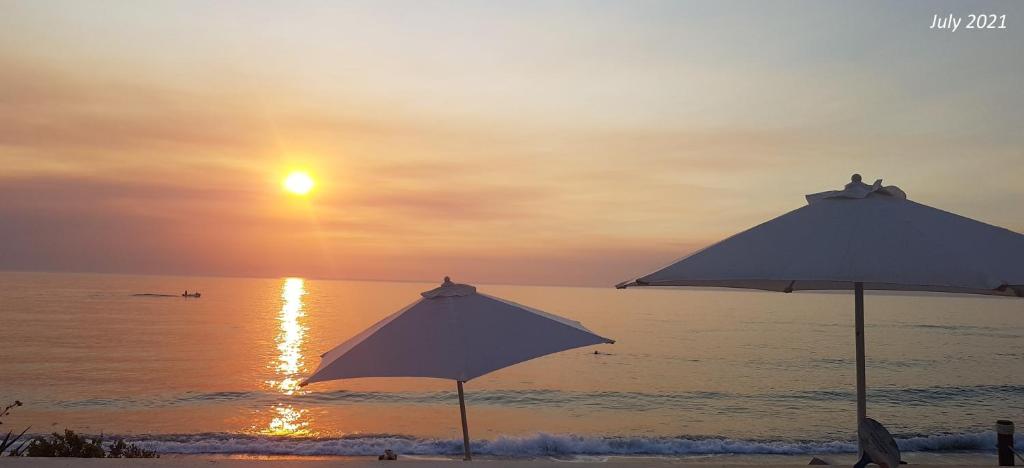 twee parasols op een strand met zonsondergang bij SeaFront family beachouse in Cyprus near Polis in Kato Yialia
