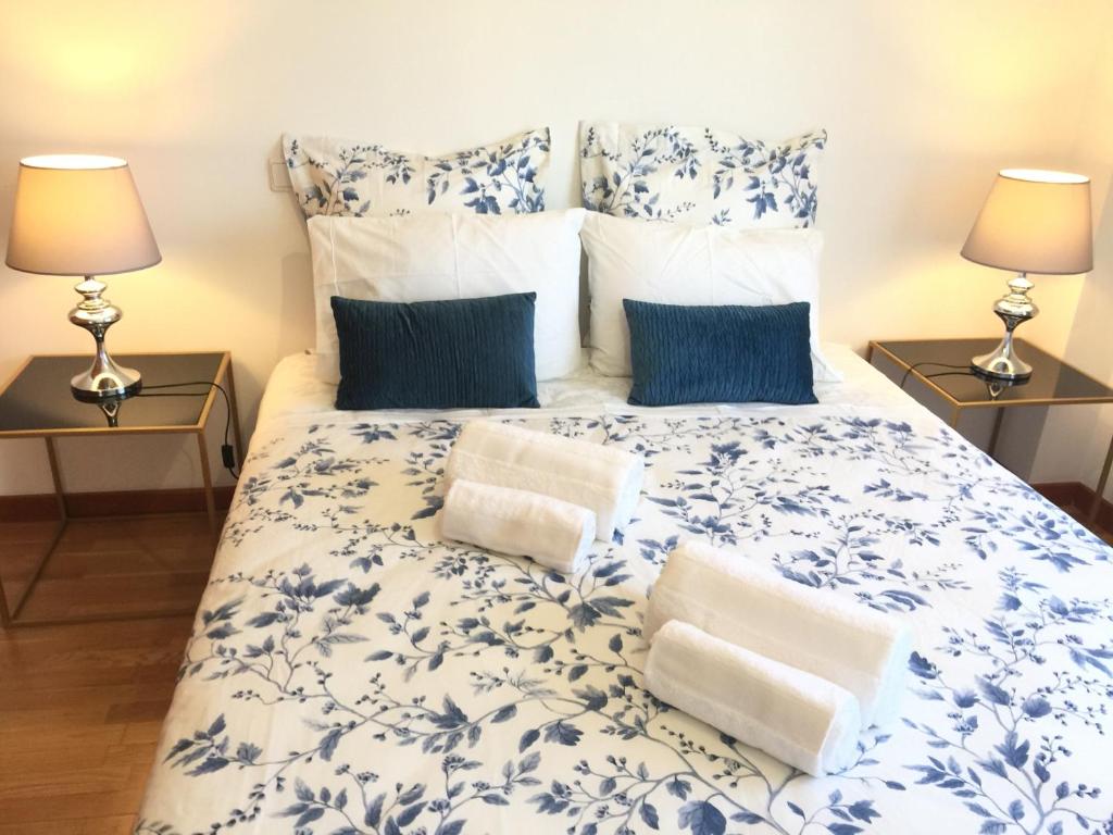 a bedroom with a blue and white bed with two lamps at Miguel Torga River in Coimbra