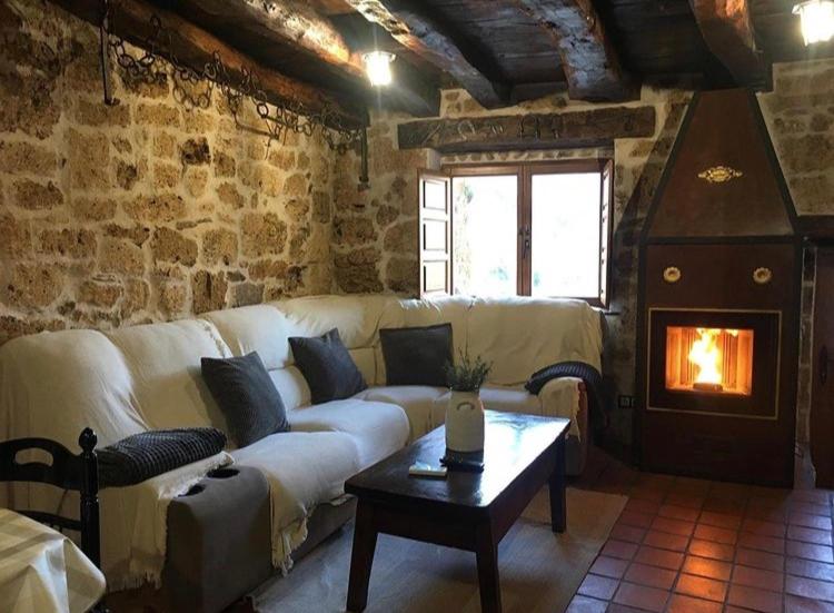 sala de estar con sofá blanco y chimenea en El Salto del Agua, en Orbaneja del Castillo