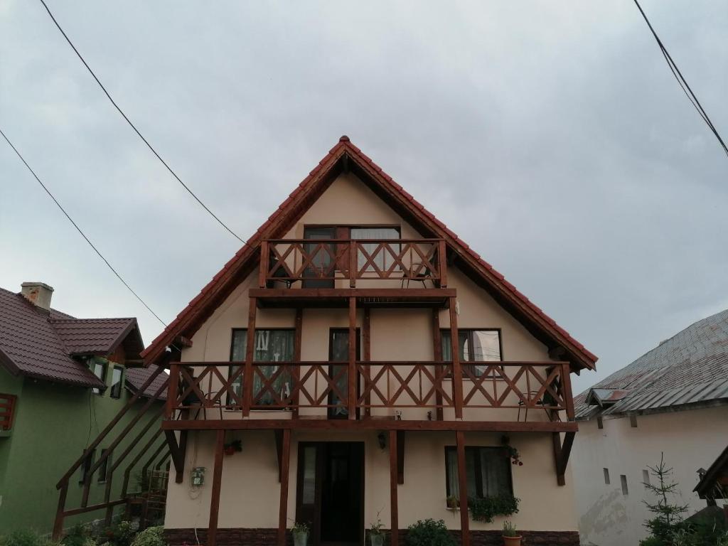 a house with a balcony on top of it at Pensiunea Tania in Ranca