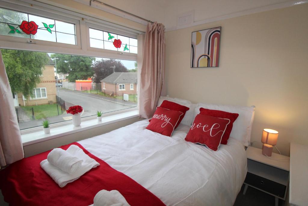 a bedroom with a bed with red pillows and a window at Brookdale House in Skegby