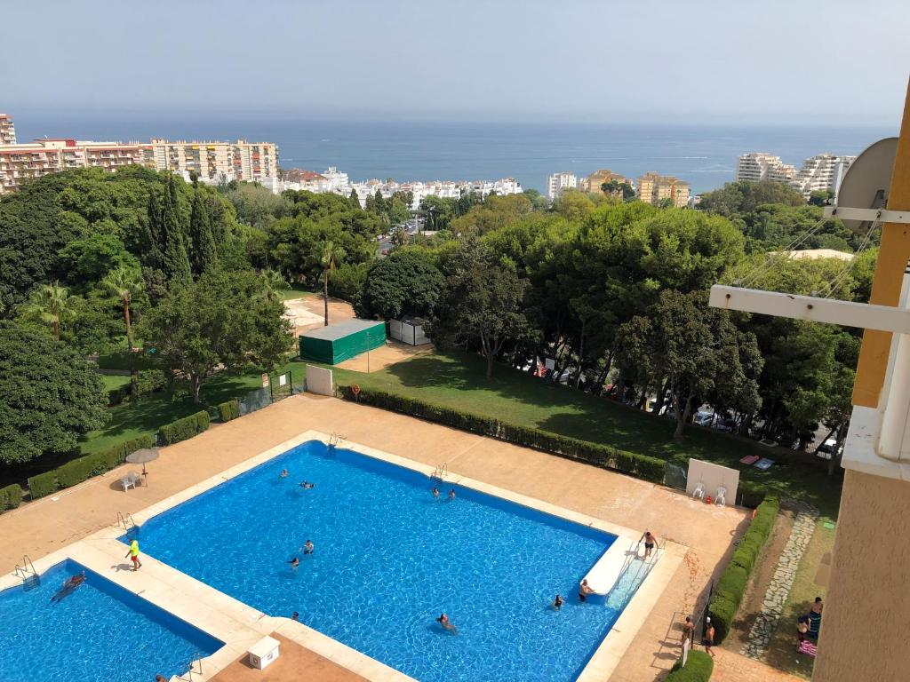een uitzicht over een zwembad met de oceaan op de achtergrond bij Hercules estudio con vistas al mar in Benalmádena