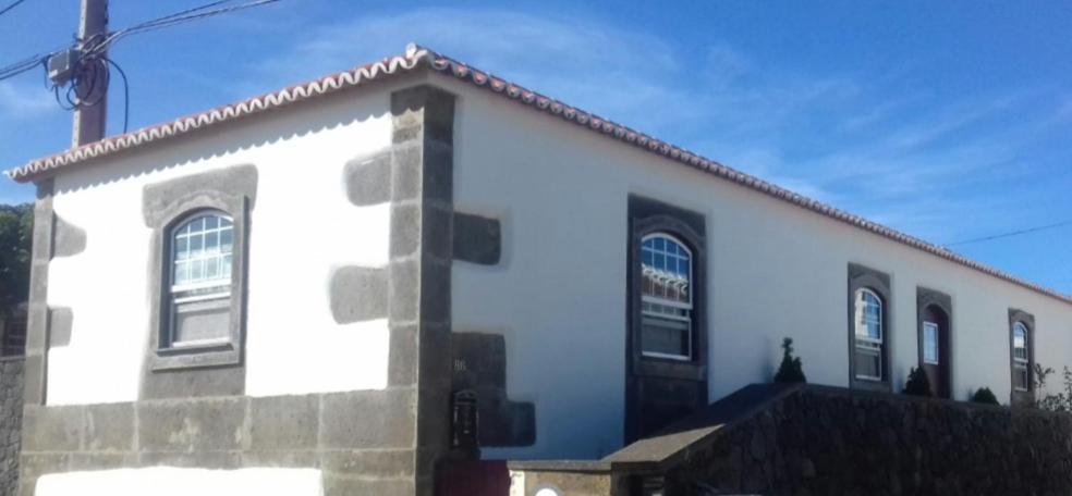 un edificio bianco con finestre sul lato di Casa do Outeiro - AL a Praia da Vitória