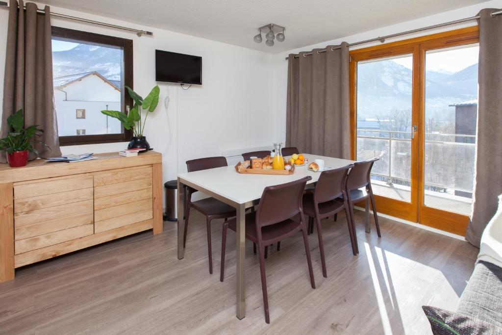 een keuken en eetkamer met een tafel en stoelen bij Le Signal du Prorel in Briançon