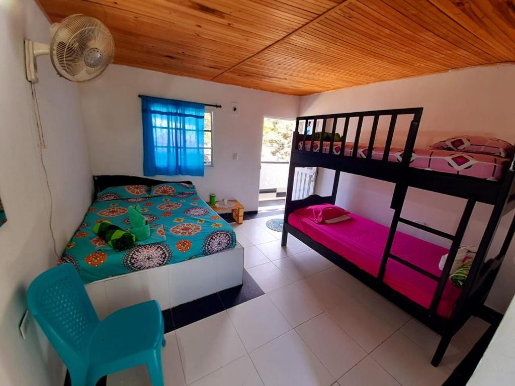 a bedroom with two bunk beds and a chair at Hotel Minca Express Relax in Minca