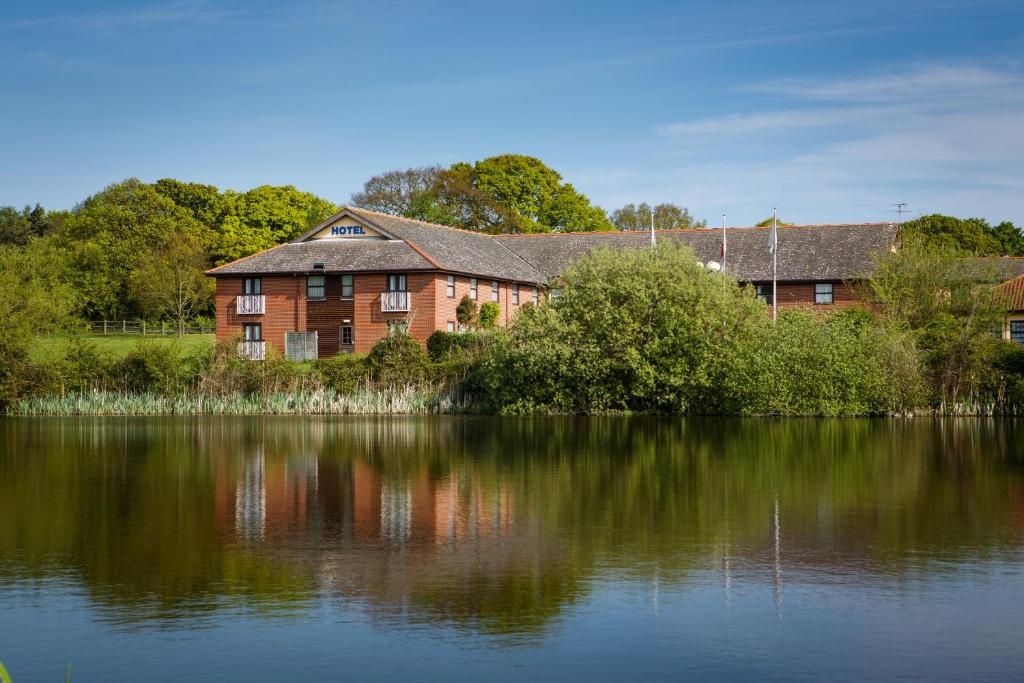 コルチェスターにあるDragonfly Hotel Colchesterの大きな煉瓦造りの大水の横の建物