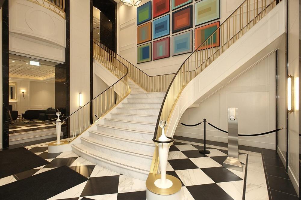 a spiral staircase in a building with a checkered floor at Stylish Downtown Toronto Residential Hotel in Toronto