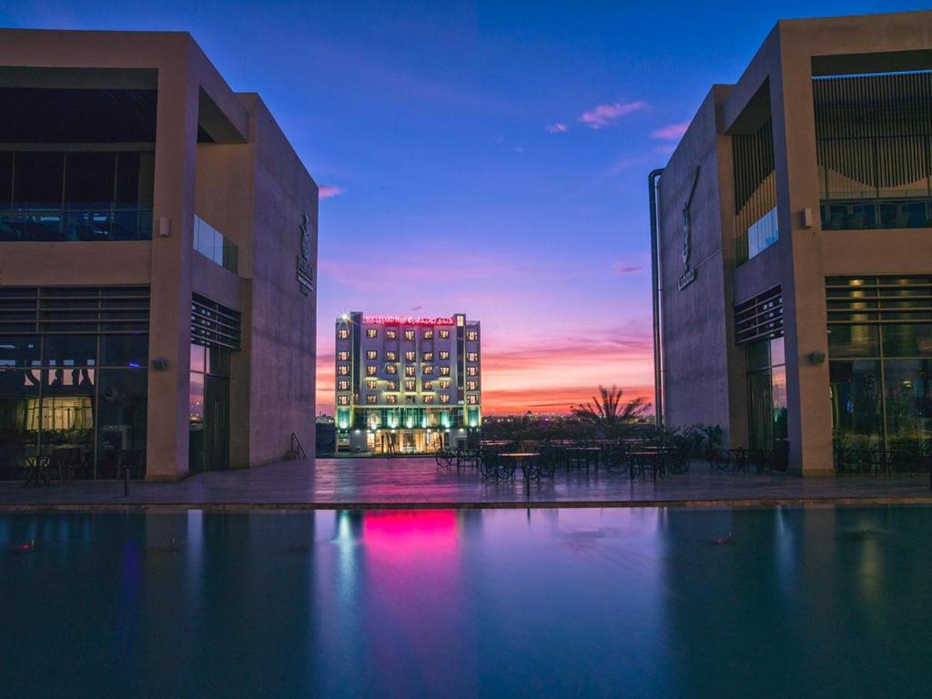 a view of a building with a sunset in the background at Boulevard Hotel Oman in Seeb
