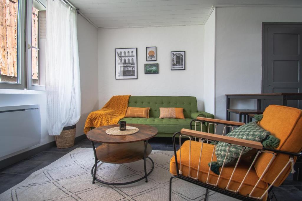 sala de estar con sofá verde y mesa en Appartement Opale Bourg d'Oisans en Le Bourg-dʼOisans
