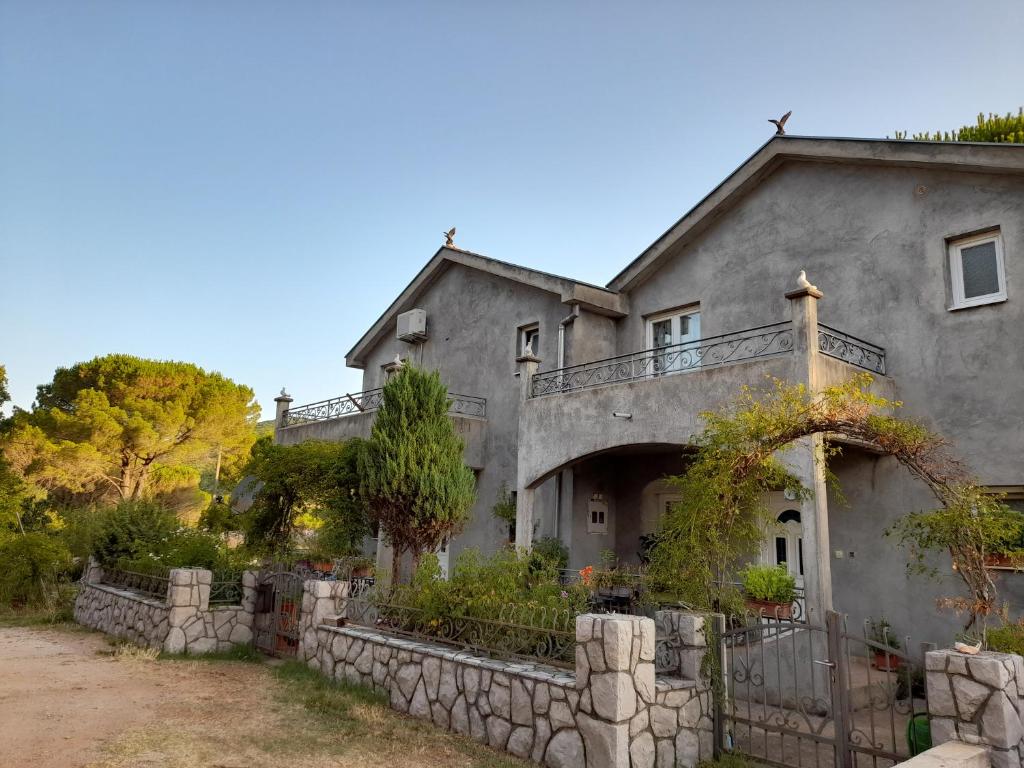 a large gray house with a stone wall at Kuća - vikendica in Kotor
