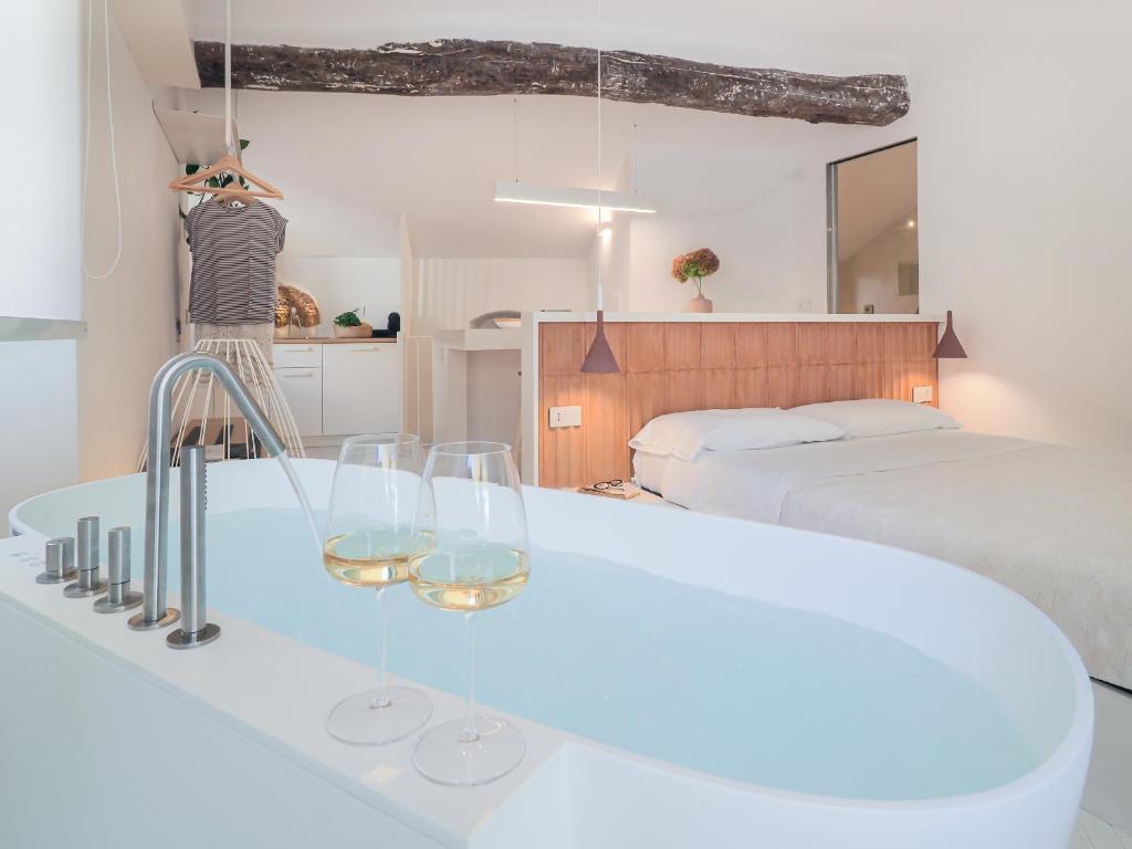 a bedroom with a bed and two wine glasses on a counter at Dreamers Sea View in Manarola