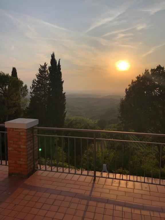 einen Blick auf den Sonnenuntergang vom Balkon eines Hauses in der Unterkunft Appartamento con vista sulle colline Toscane in Montespertoli