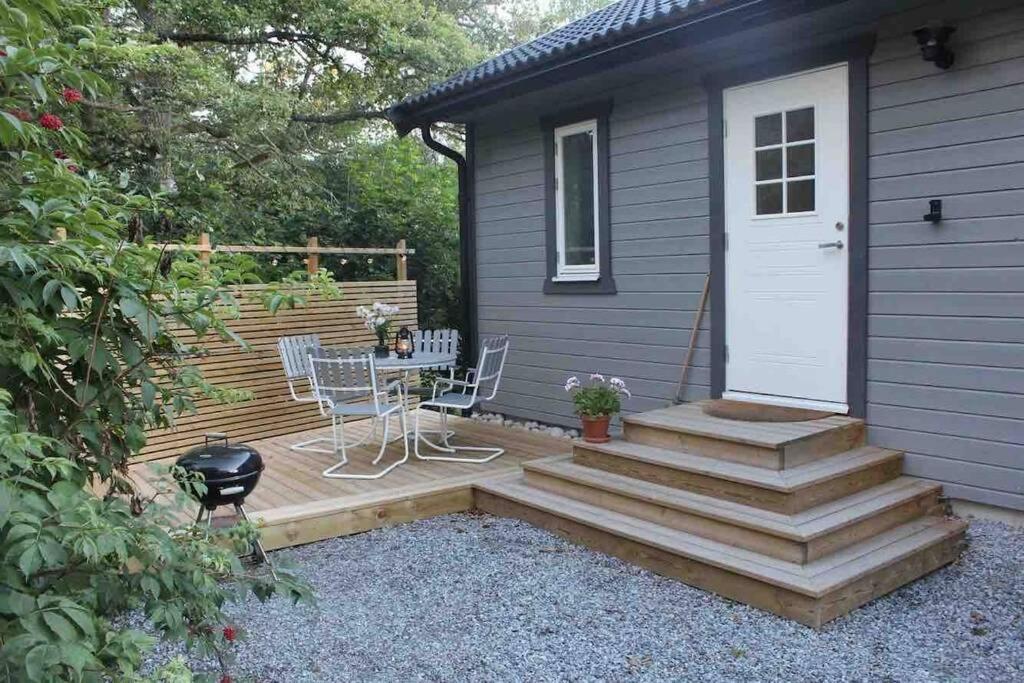 a patio with a table and stairs to a house at Cottage perfect for short time rent in Gustavsberg
