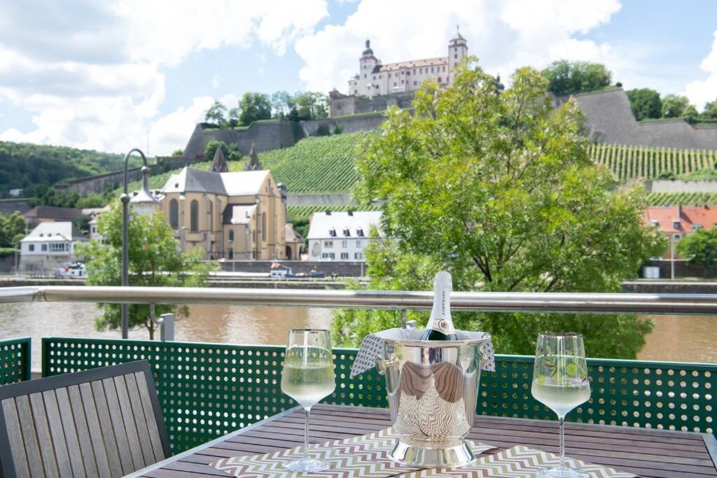 een tafel met twee glazen wijn op een balkon bij Ferienwohnung Panorama mit Festungsblick in Würzburg