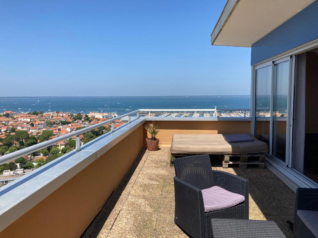 a balcony with chairs and a view of the ocean at Plein Ciel Vue Bassin in Arcachon