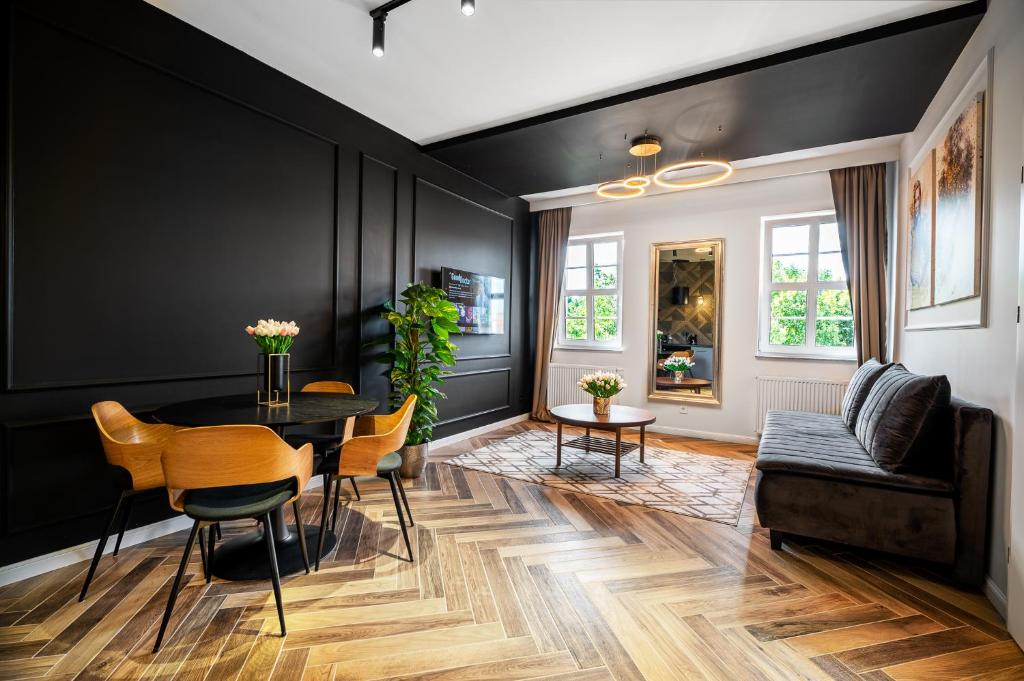 une salle à manger avec des murs noirs, une table et des chaises dans l'établissement BanApart Exclusive Apartments, à Zgorzelec