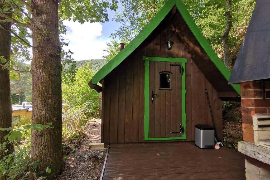 una casa exterior de madera con techo verde en Heksenhuis, en Goebelsmuhle