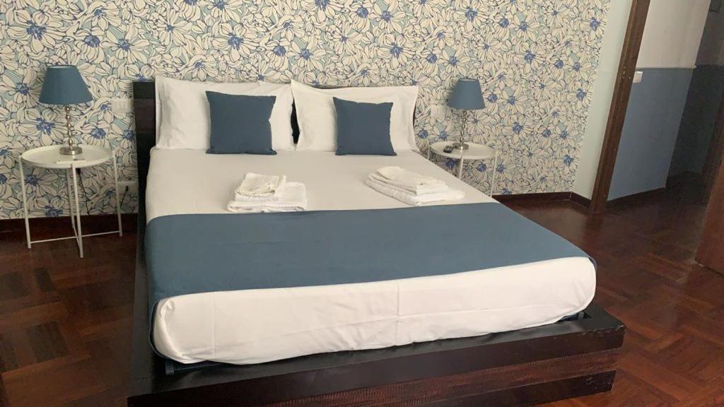a large bed in a room with two tables at Folle Città B&B in Naples