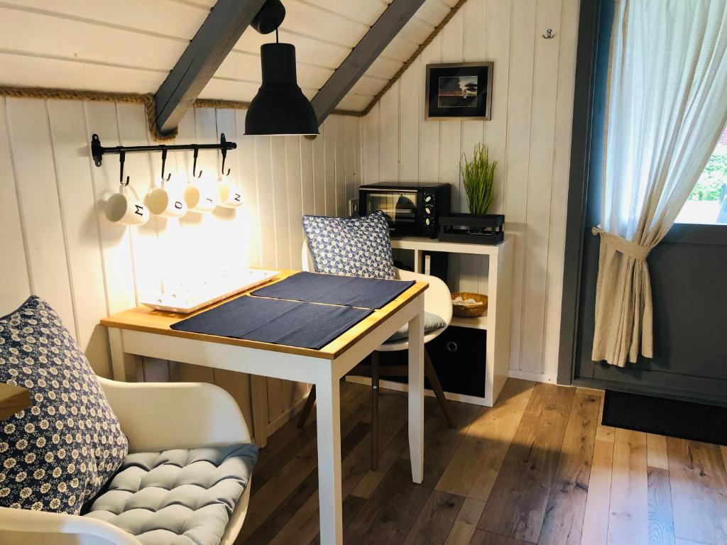 a kitchen with a desk and a table and a couch at Ferienhaus Vogelkoje in Emmelsbüll-Horsbüll