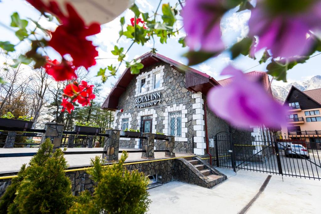 un edificio con flores rosas delante de él en Royal Inn Busteni-Adults Only, en Buşteni