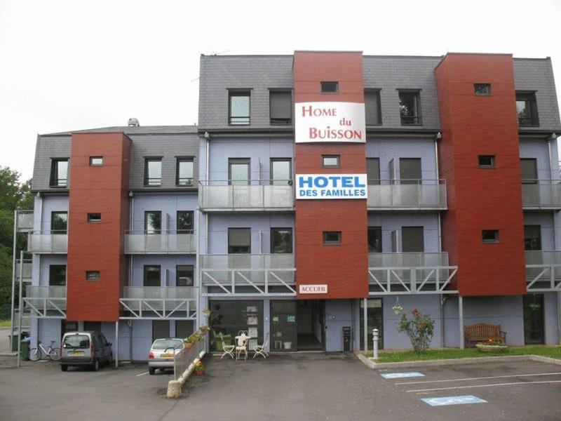 un hotel con un estacionamiento delante de él en HOME DU BUISSON Hôtel des Familles en Isle