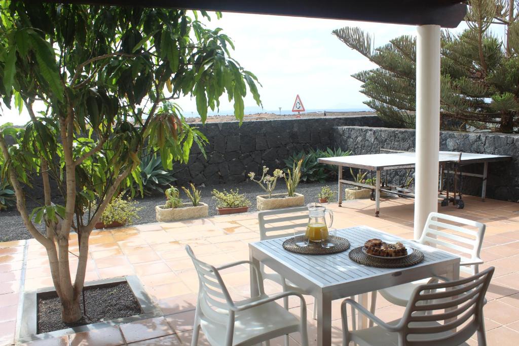a table and chairs on a patio with a view of the ocean at VILLA RAQUEL in Yaiza