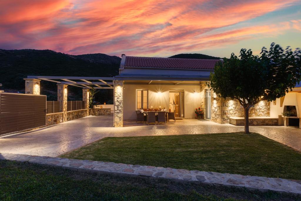 Villa 4 DESTINA في Élos: منزل مع حديقة أمام غروب الشمس