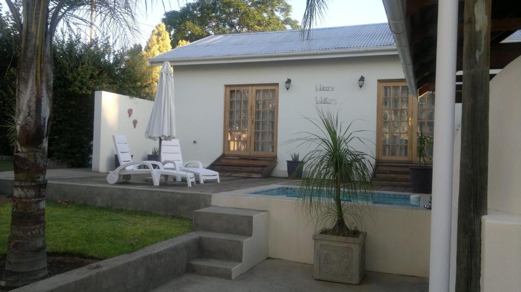 a villa with a swimming pool and a house at B&B on Church in Oudtshoorn