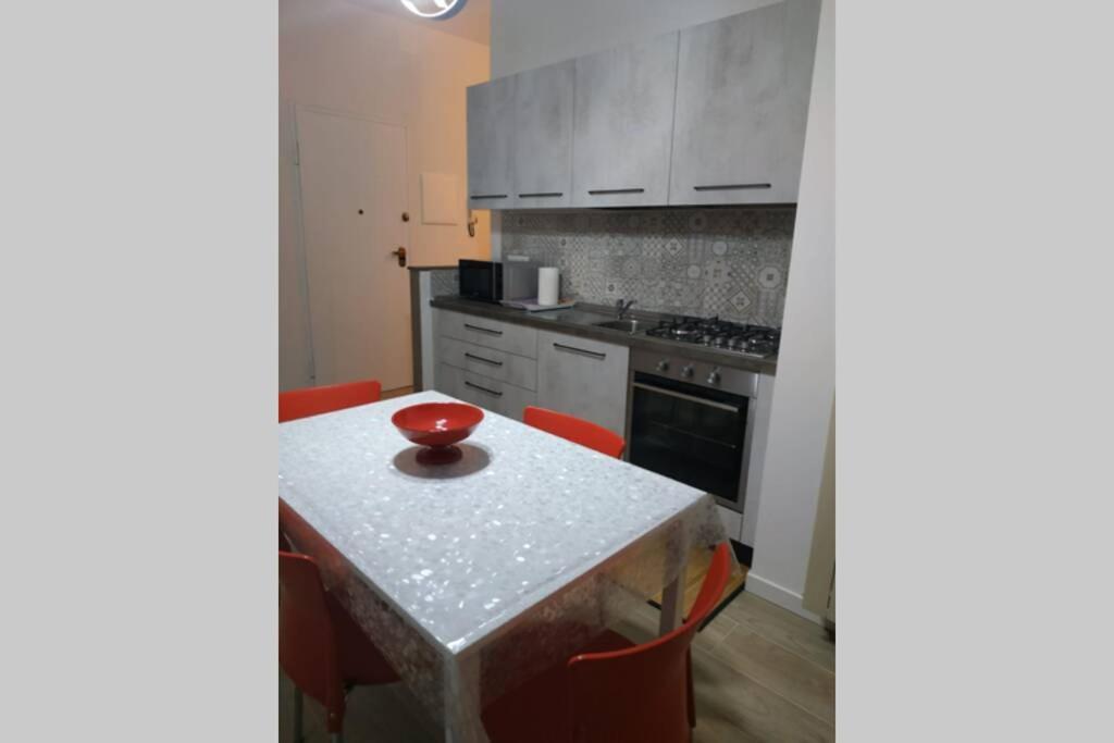 kuchnia ze stołem z czerwoną miską w obiekcie Feel at Home - CASA LA POSTA w mieście Lovere