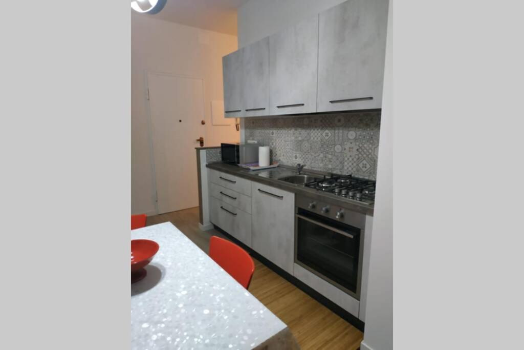 kuchnia ze sprzętem ze stali nierdzewnej i stołem w obiekcie Feel at Home - CASA LA POSTA w mieście Lovere