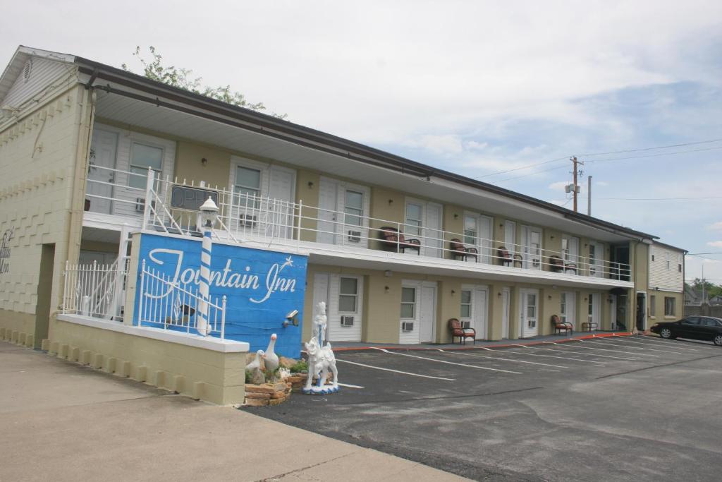 a building with a dog sitting in a parking lot at Fountain Inn in Van Wert