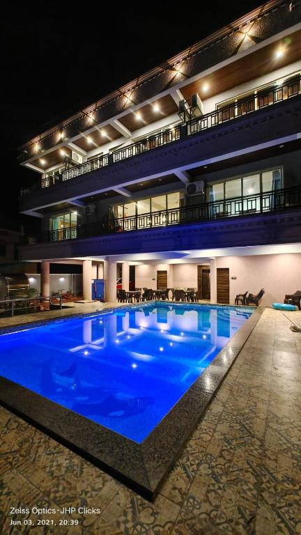 a large blue swimming pool in a building at night at Polsburg Panchgani in Panchgani