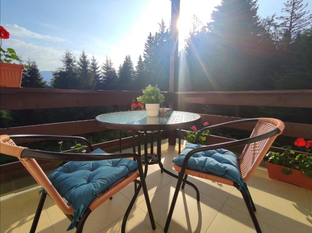 a patio table and two chairs on a balcony at Green Studio in Predeal