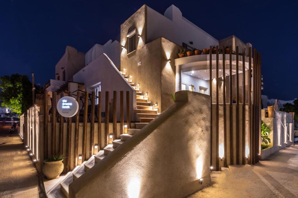 a building with a fence and stairs with lights at The Artemis Hotel in Agia Anna Naxos