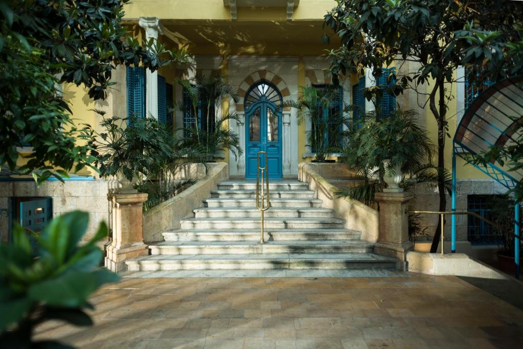 ein Gebäude mit einer Treppe und einer blauen Tür in der Unterkunft Albergo Hotel in Beirut