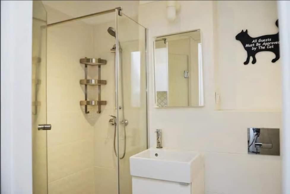 y baño con ducha, lavabo y espejo. en Apartamenty Centrum, en Varsovia