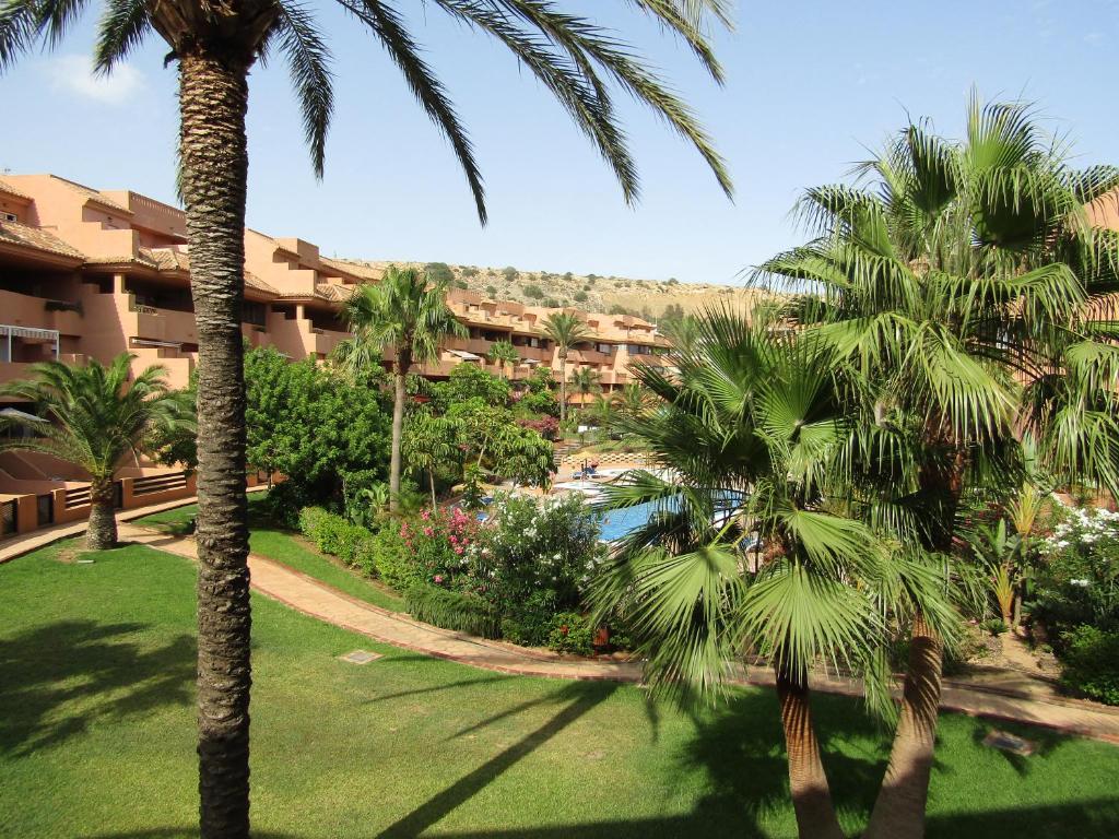 a view of a resort with palm trees and a pool at Apartementos Almerimar Golf in Almerimar