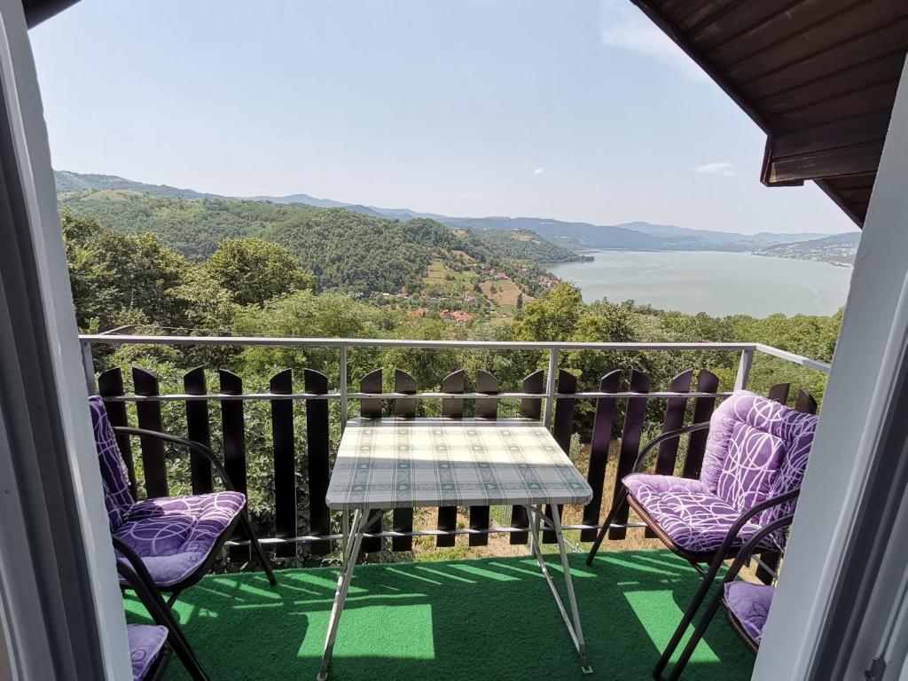 einen Tisch und Stühle auf einem Balkon mit Aussicht in der Unterkunft Apartman Jaredić - Private Accommodation, Privatni Smeštaj in Donji Milanovac