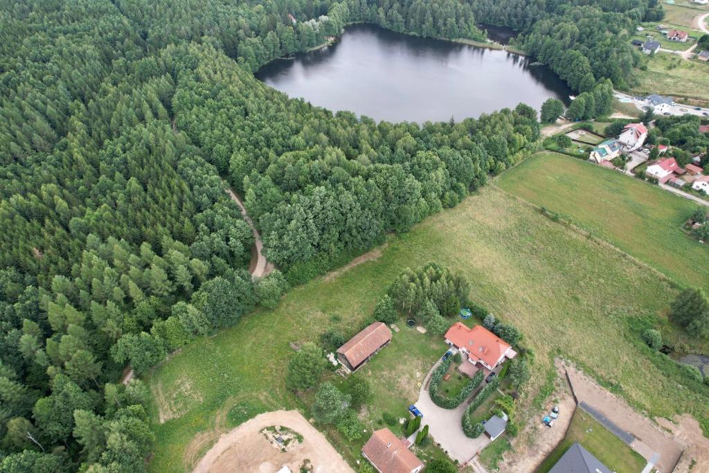 eine Luftansicht eines Bauernhofs mit einem Haus und einem See in der Unterkunft Spokojny Zakątek in Mrągowo
