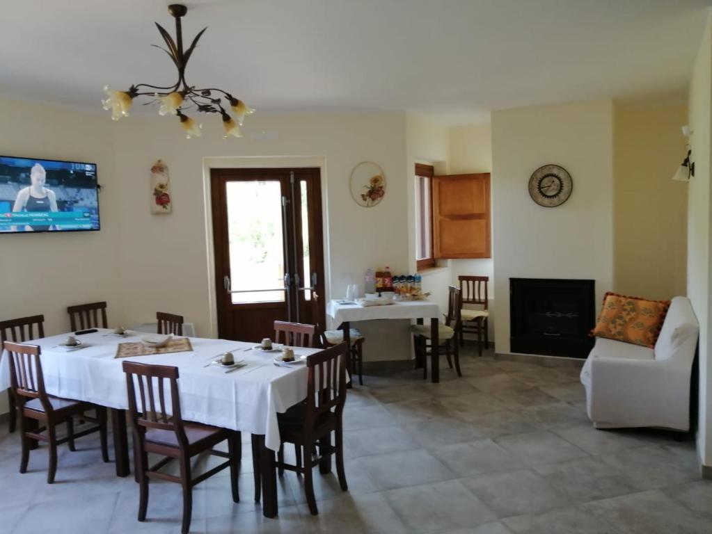 a dining room with a white table and chairs at Agriturismo CuoreLieto del Cilento in Corleto Monforte