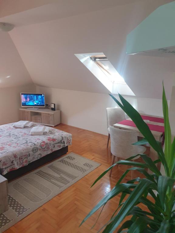 Un dormitorio con una cama y una planta en una habitación en Apartment Loft en Čačak