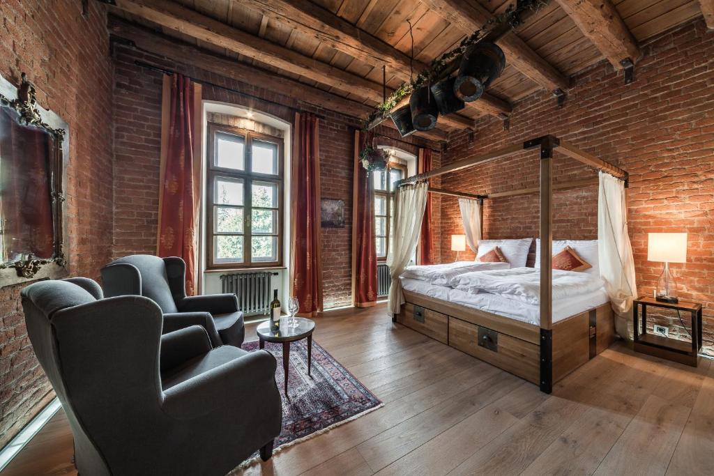 een slaapkamer met een bed in een bakstenen muur bij Hotel Mariánský Dvůr in Uherské Hradiště