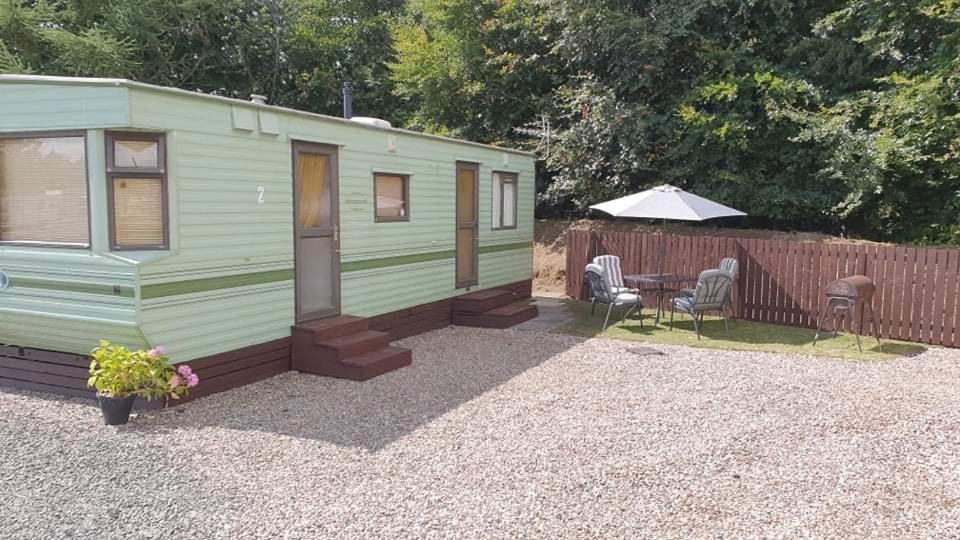 a small green caravan with a table and chairs at Tummel 2 in Forfar