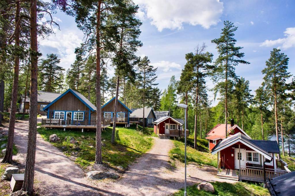 a group of cottages in a forest with trees at Falun Strandby Främby Udde in Falun