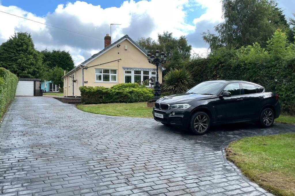 un coche negro estacionado frente a una casa en Detached Bungalow II Big Garden II Pet Friendly en Hednesford