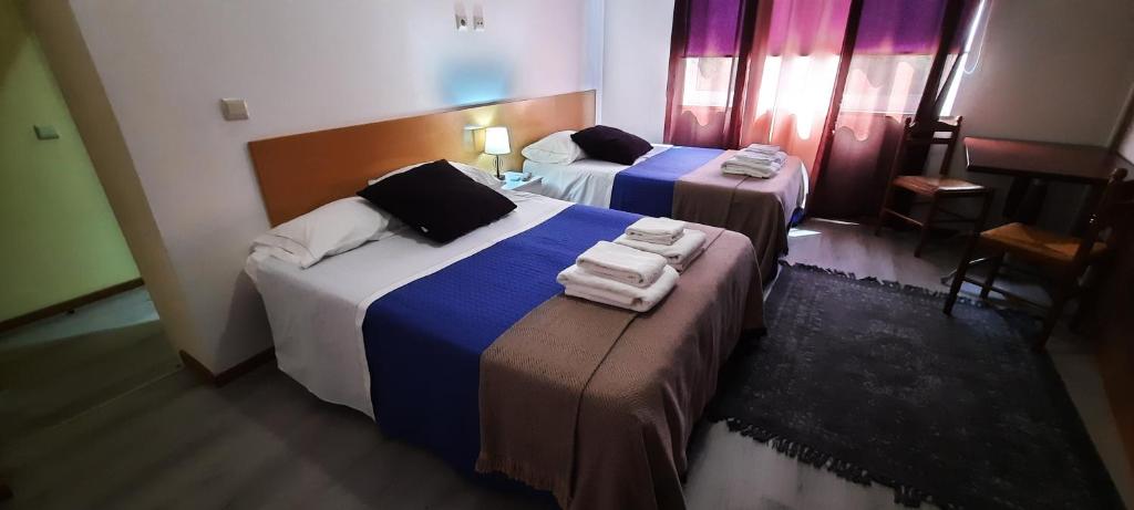 2 łóżka w pokoju hotelowym z ręcznikami w obiekcie Vale do Rodo Residencial w mieście Peso da Régua