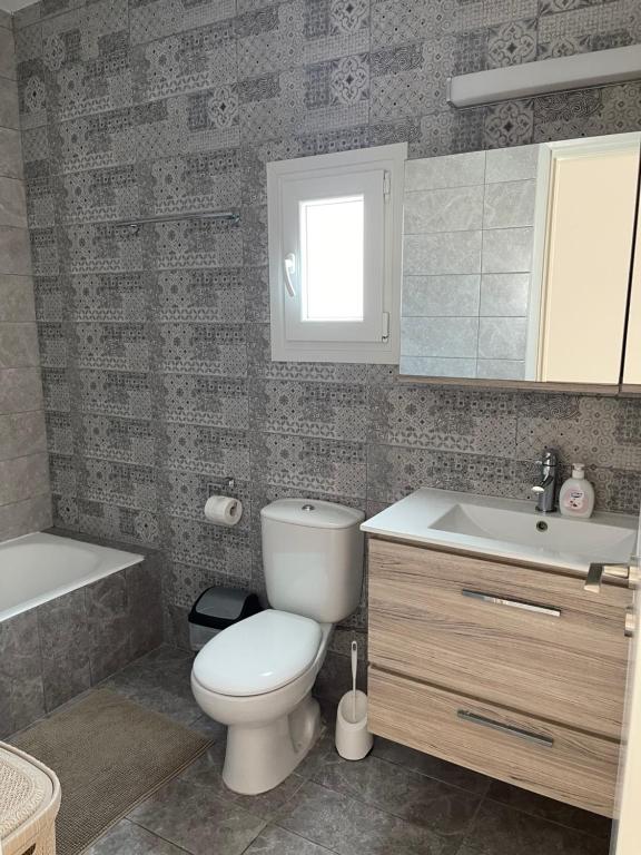 a bathroom with a toilet and a sink and a tub at Julipapas Gardens in Paphos