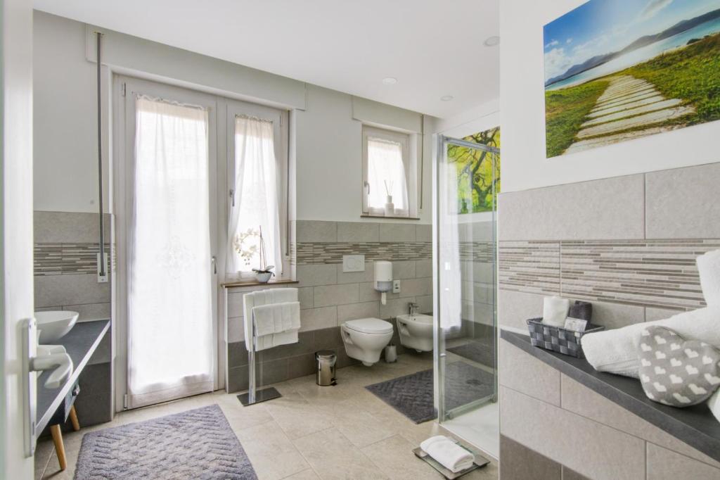 łazienka z toaletą, umywalką i oknem w obiekcie CEJM Apartments Merano w Meranie
